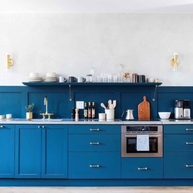 blue and brass kitchen with coffee makers apartment refrigerator and built in combi oven