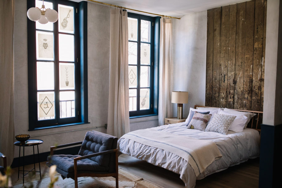 hotel room with queen bed and floor to ceiling historic windows